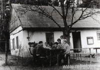 Děti společně jedí před chalupou